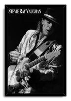 Stevie Ray Vaughan framed wall art print presents a black-and-white guitarist portrait, black hat, electric guitar, and bold name lettering.
