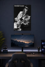 Stevie Ray Vaughan in a gaming desk setup above a monitor.