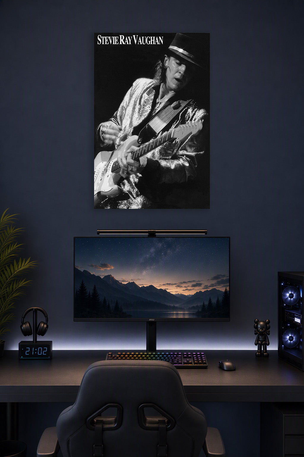 Stevie Ray Vaughan in a gaming desk setup above a monitor.