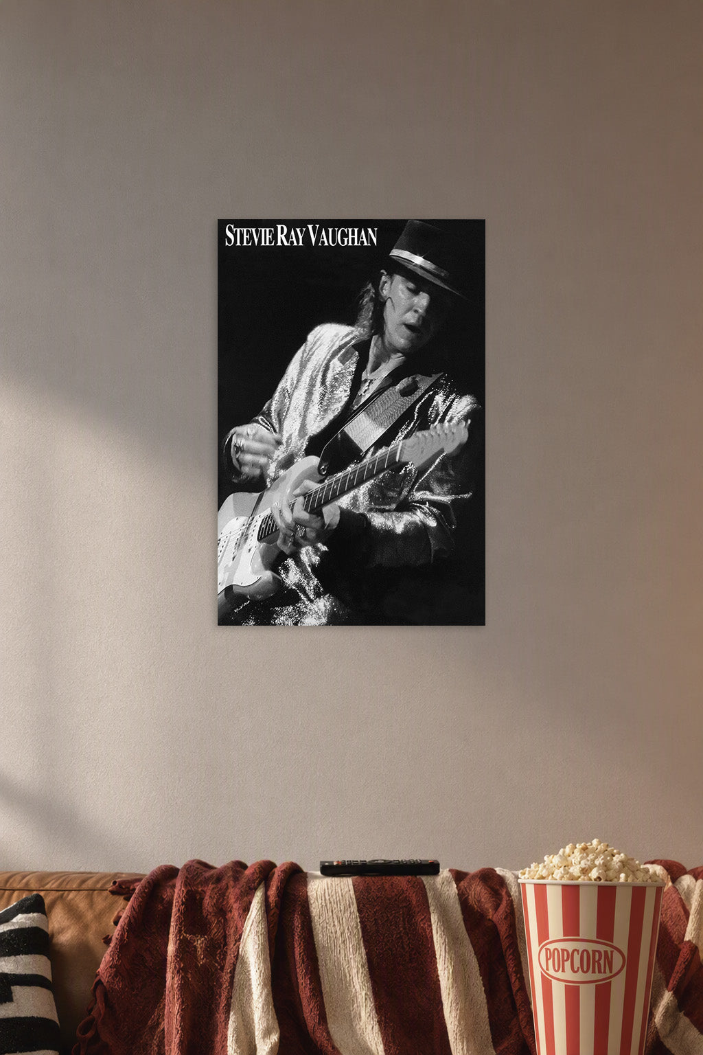 Stevie Ray Vaughan in a cozy movie room above a brown sofa with popcorn.