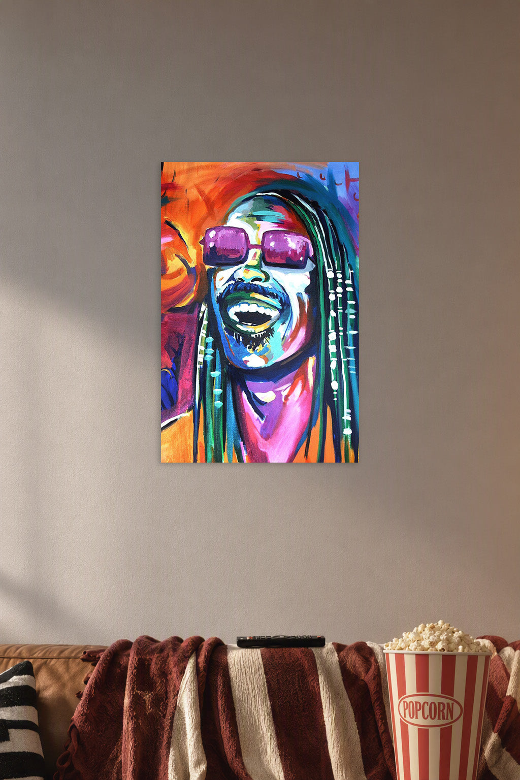 Stevie Wonder in a cozy movie room above a brown sofa with popcorn.