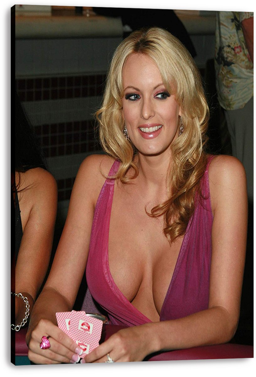 Stormy Daniels canvas wall art print displays her seated at a card table with playing cards, styled in a vivid pink dress.