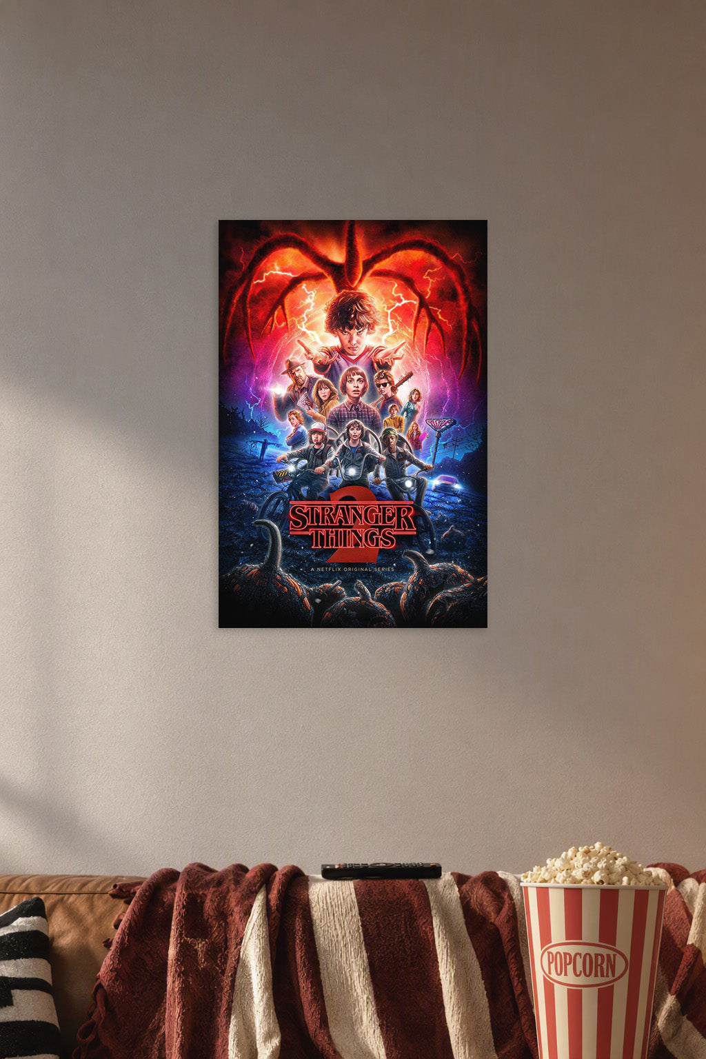 Stranger Things 2 in a cozy movie room above a brown sofa with popcorn.