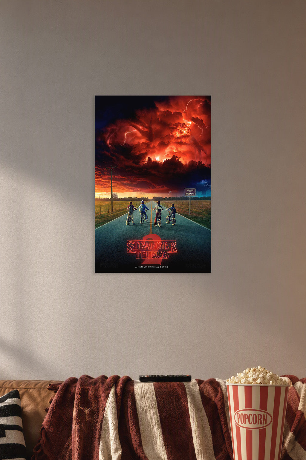 Stranger Things 2 in a cozy movie room above a brown sofa with popcorn.