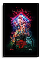 Stranger Things 3 framed wall art print depicts Eleven, the cast, colorful fireworks, Starcourt signage, and a large dark creature.
