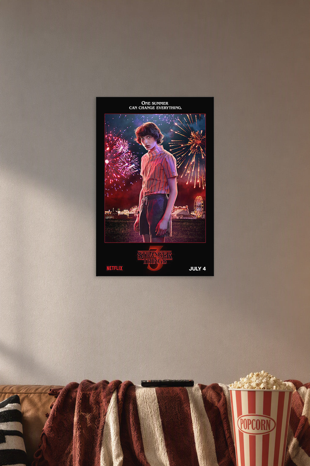 Stranger Things 3 Mike Wheeler in a cozy movie room above a brown sofa with popcorn.