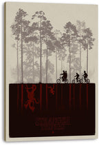 Stranger Things canvas wall art displays three cyclists in a foggy forest over red inverted figures and the series logo.