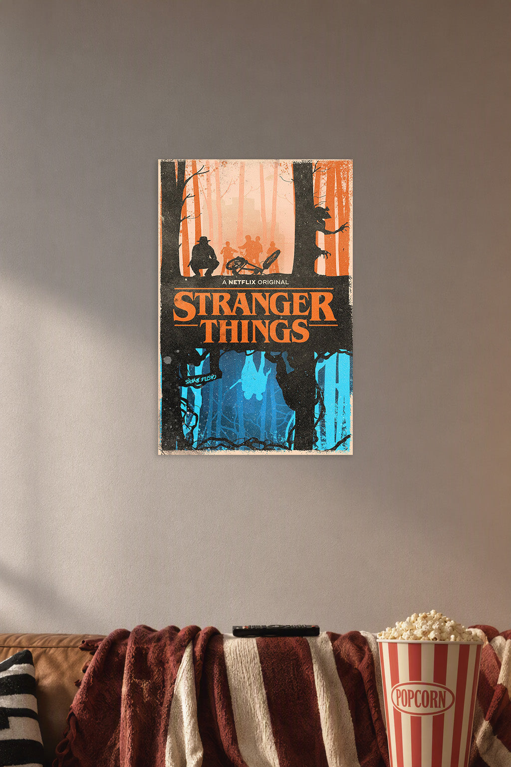 Stranger Things in a cozy movie room above a brown sofa with popcorn.