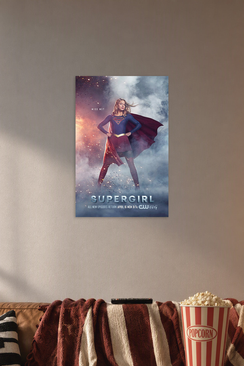 Supergirl in a cozy movie room above a brown sofa with popcorn.