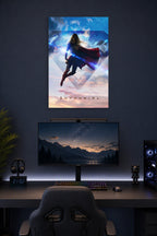 Supergirl in a gaming desk setup above a monitor.