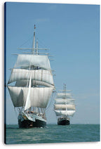 Tall ships canvas wall art print displays two white-sailed vessels at sea beneath a clear pale-blue sky.