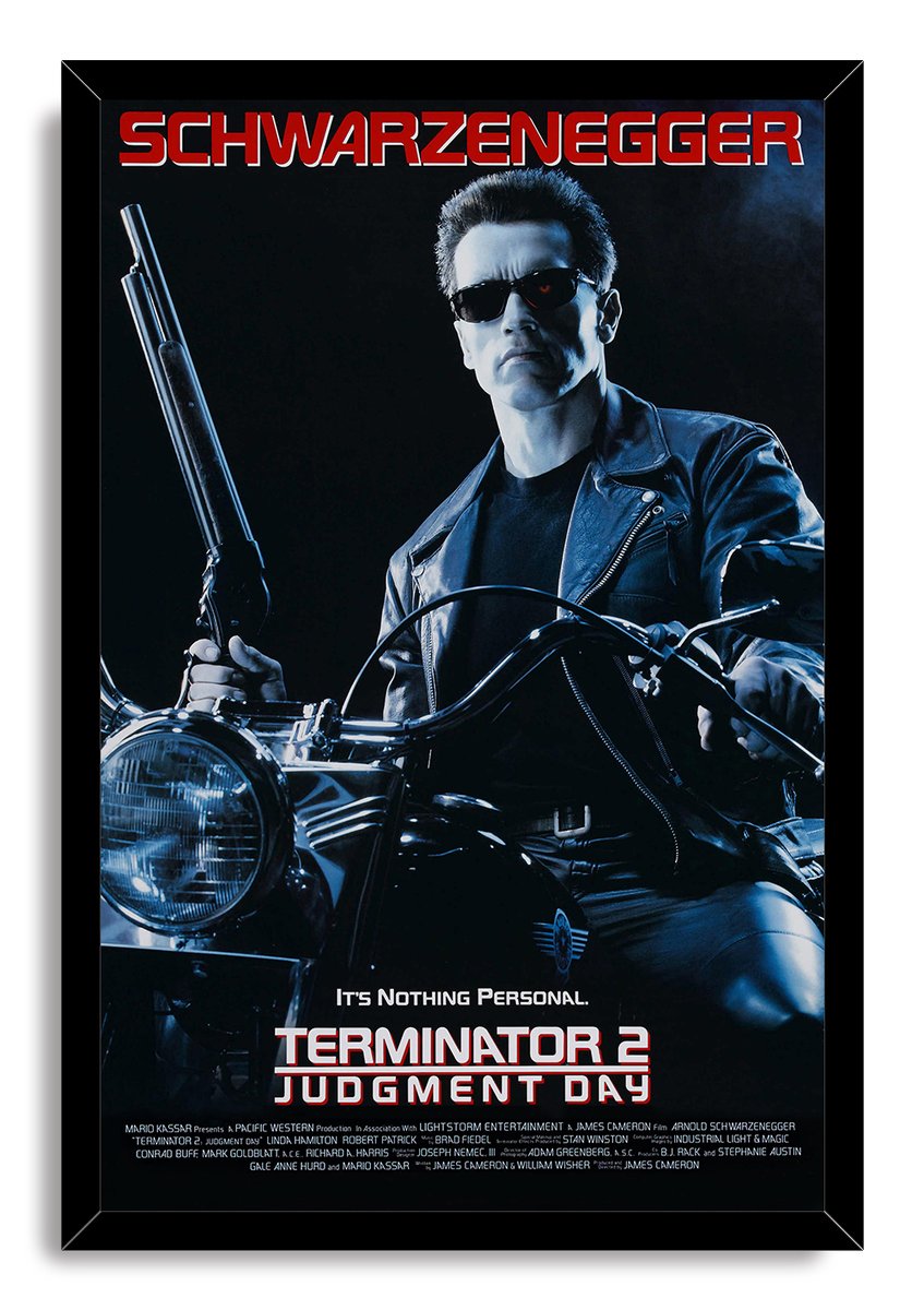 Terminator 2 framed wall art print featuring Arnold Schwarzenegger in dark sunglasses, leather jacket, motorcycle, and shotgun.