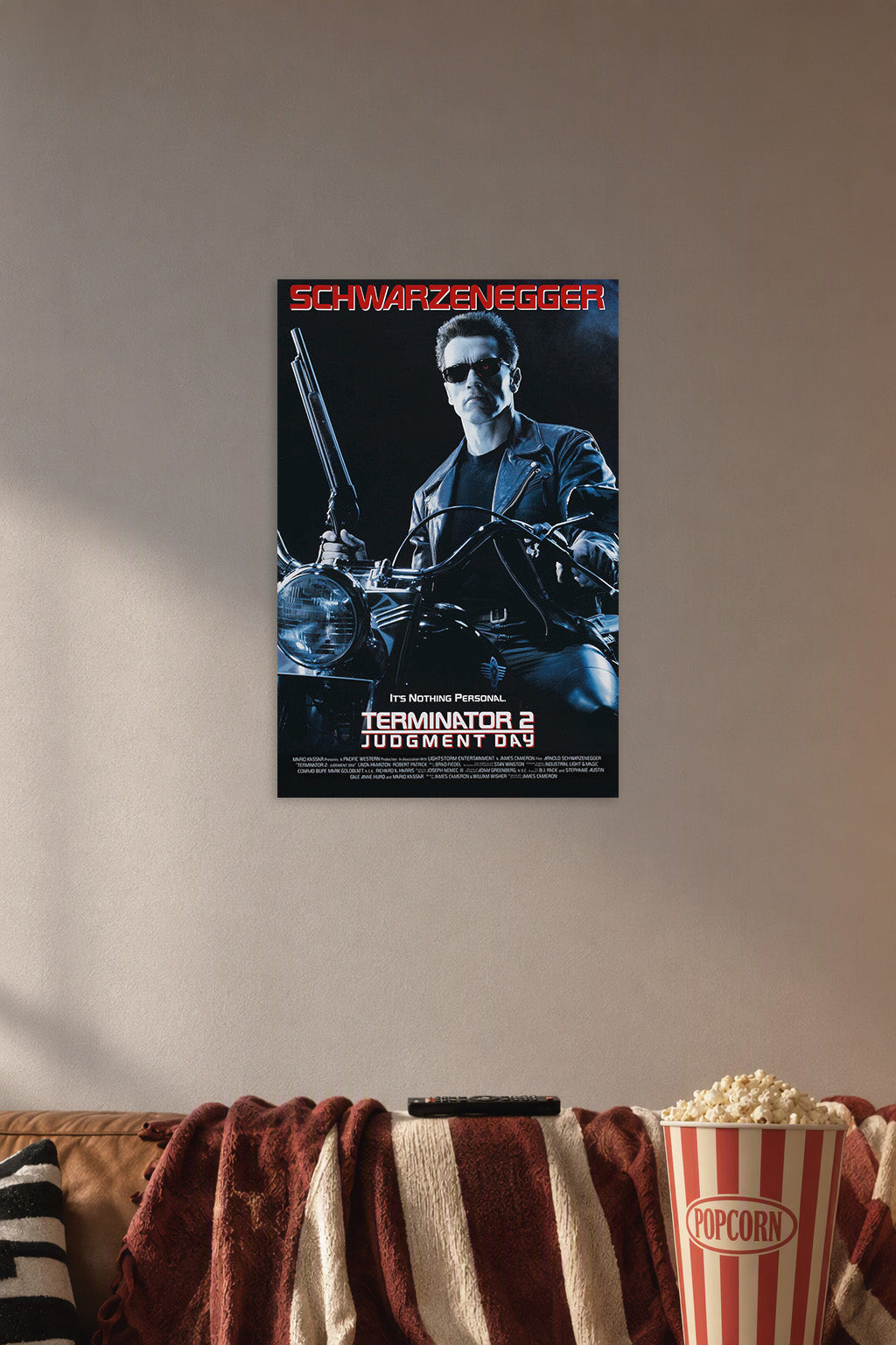 Terminator 2 Arnold Schwarzenegger in a cozy movie room above a brown sofa with popcorn.