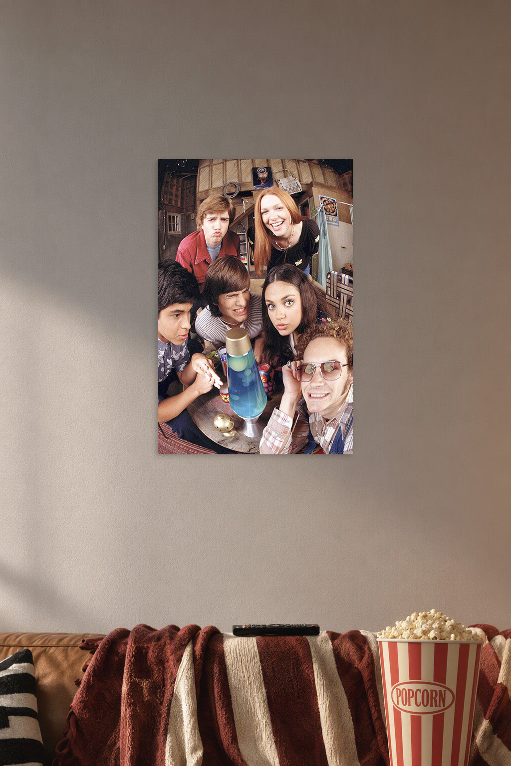 That '70s Show Cast in a cozy movie room above a brown sofa with popcorn.
