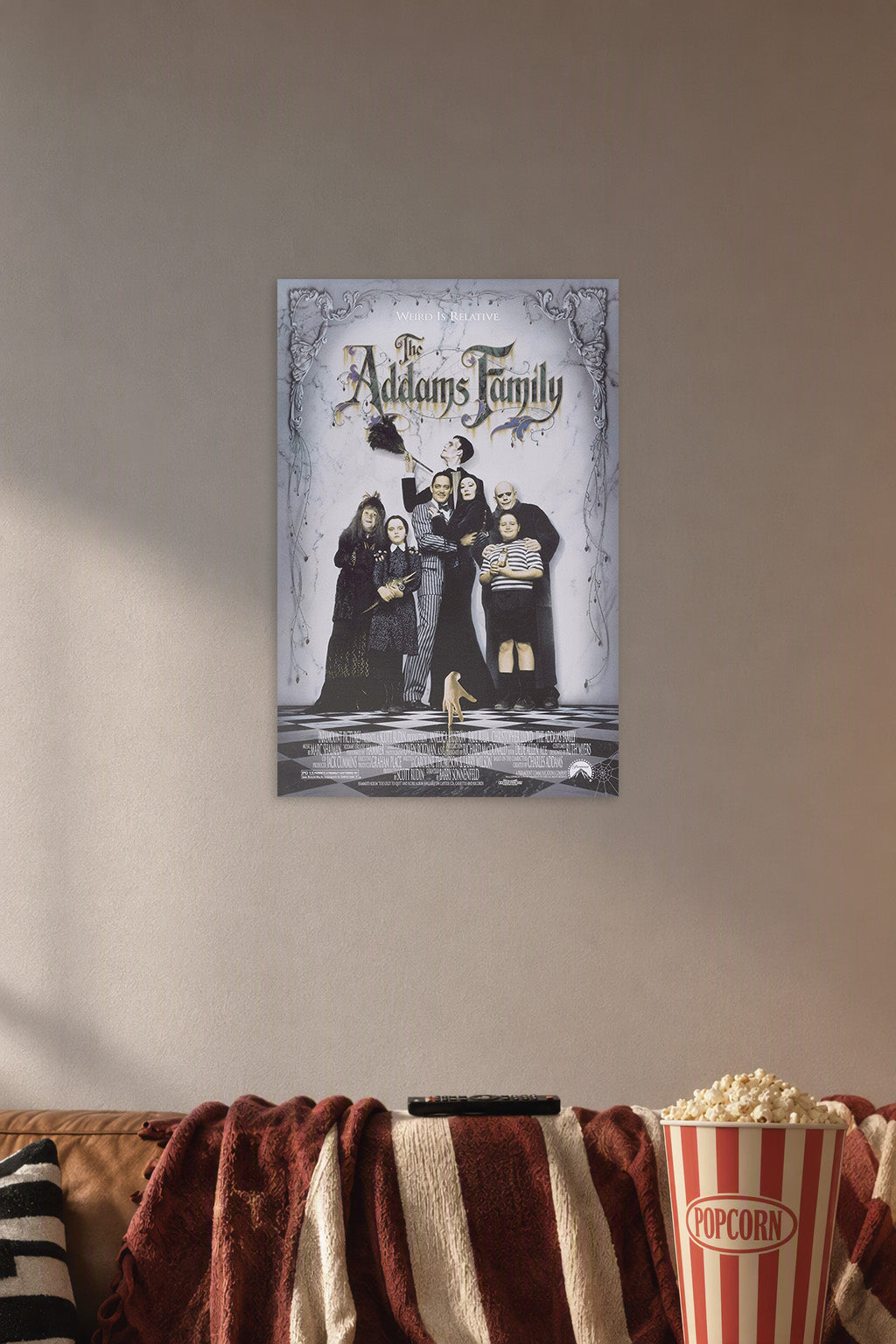 The Addams Family in a cozy movie room above a brown sofa with popcorn.