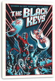 The Black Keys wall art print on canvas features superhero band figures battling lasers beneath bold blue and white lettering.