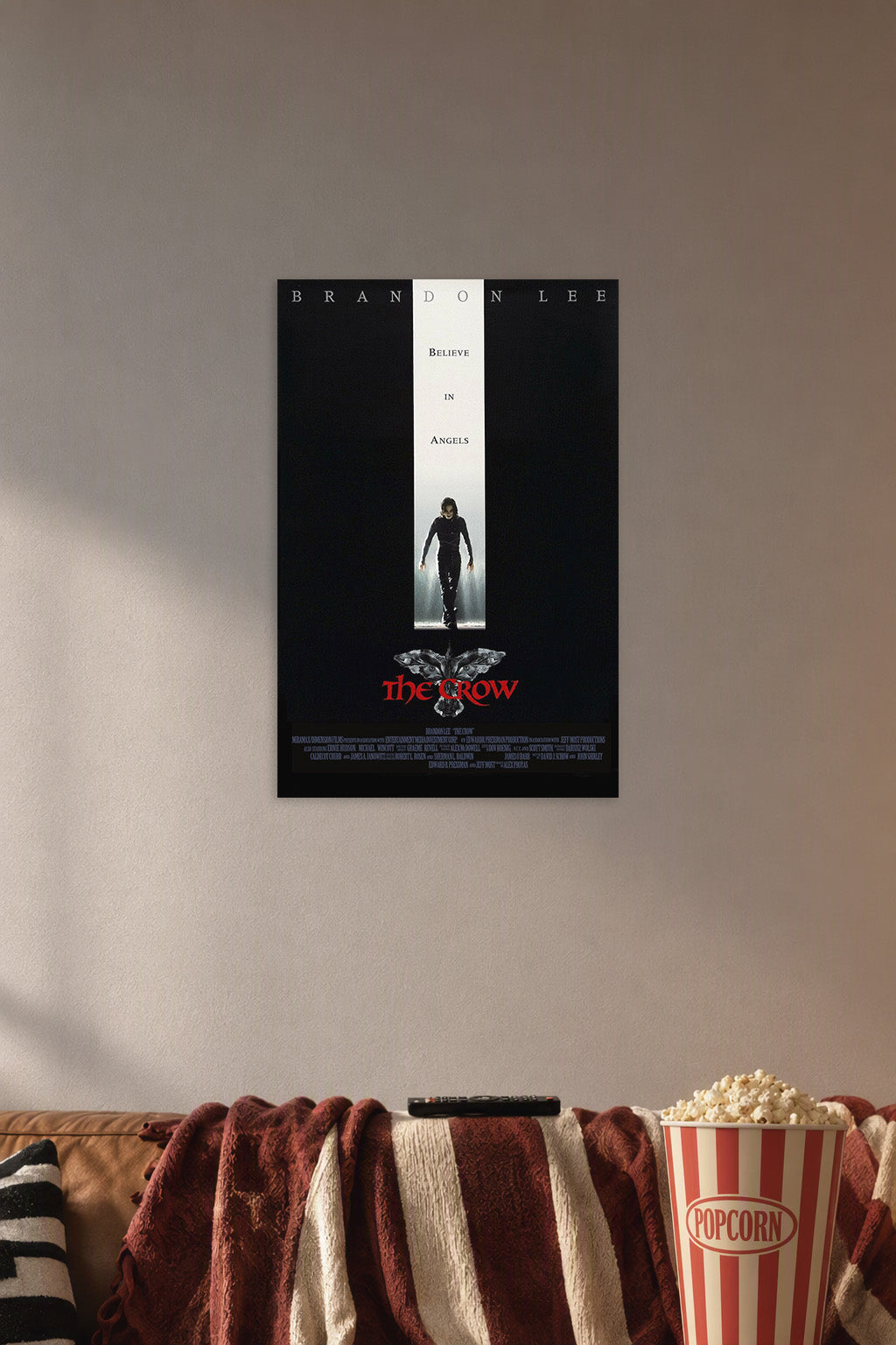 The Crow Brandon Lee in a cozy movie room above a brown sofa with popcorn.