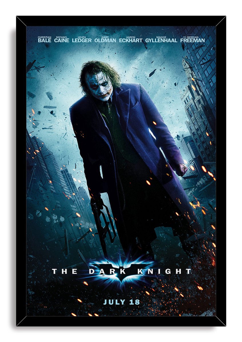 Framed The Dark Knight wall art print portrays the Joker in purple amid debris and orange sparks beneath the film title.