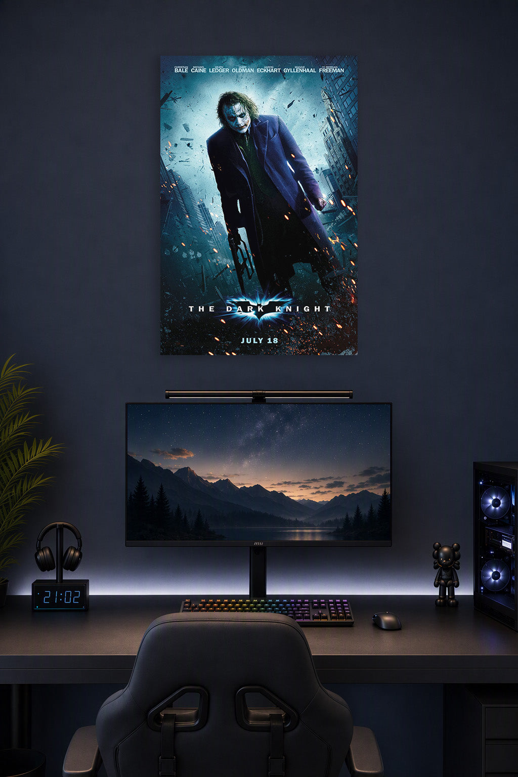 The Dark Knight Joker in a gaming desk setup above a monitor.