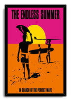 The Endless Summer framed wall art print features black surfer silhouettes, a yellow sun, pink sky, and orange beach.