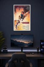 The Goonies Movie Poster in a gaming desk setup above a monitor.