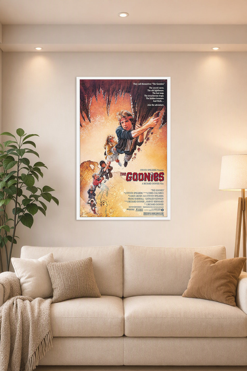 The Goonies Movie Poster in a bright living room above a beige sofa.
