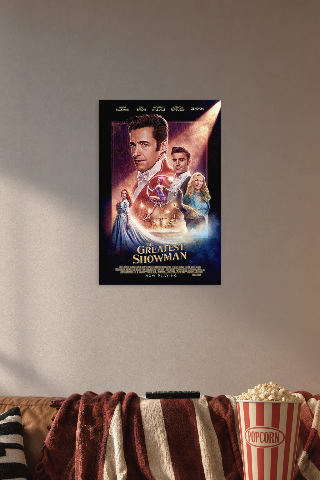 The Greatest Showman Movie Poster in a cozy movie room above a brown sofa with popcorn.