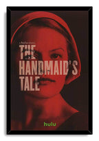 The Handmaid's Tale framed wall art print presents a red-and-black portrait of a bonneted woman behind large white title text.