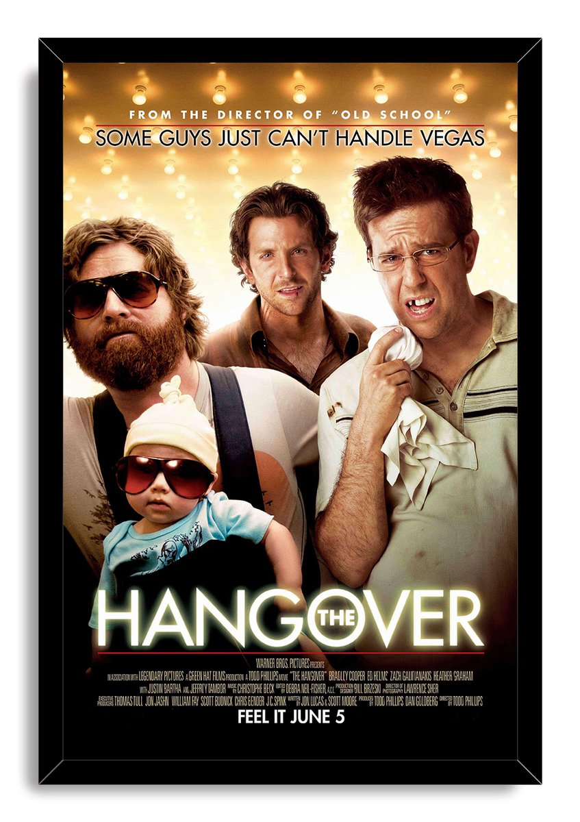 The Hangover framed wall art print presents three men, a baby in sunglasses, golden marquee lights, and the film title.