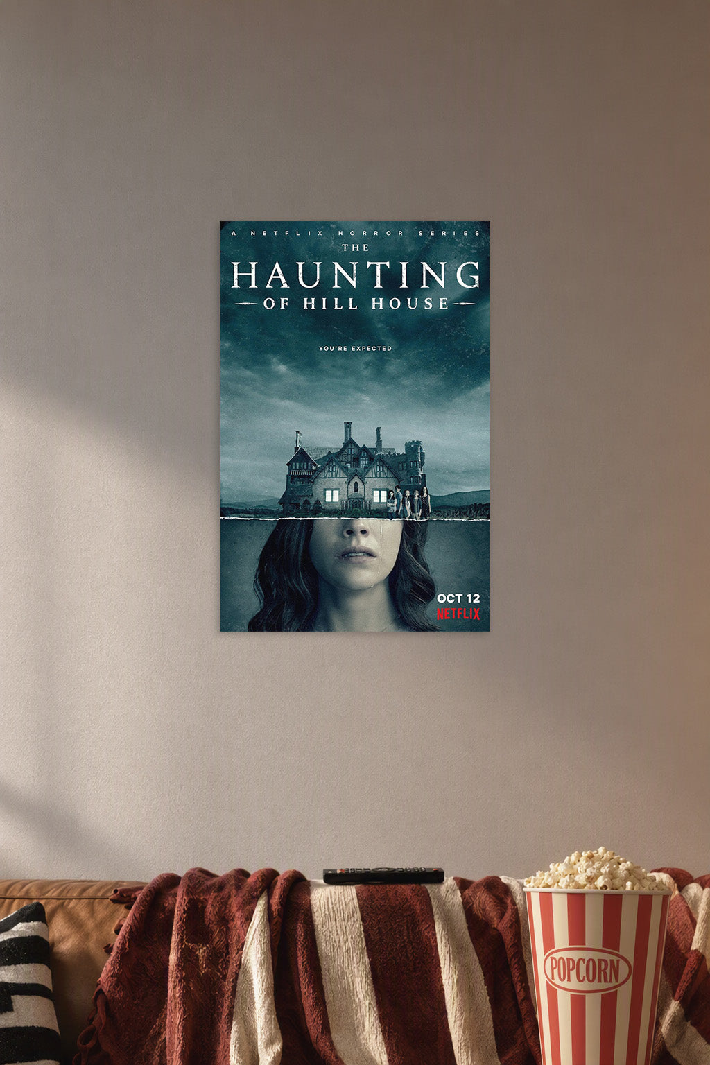 The Haunting of Hill House in a cozy movie room above a brown sofa with popcorn.