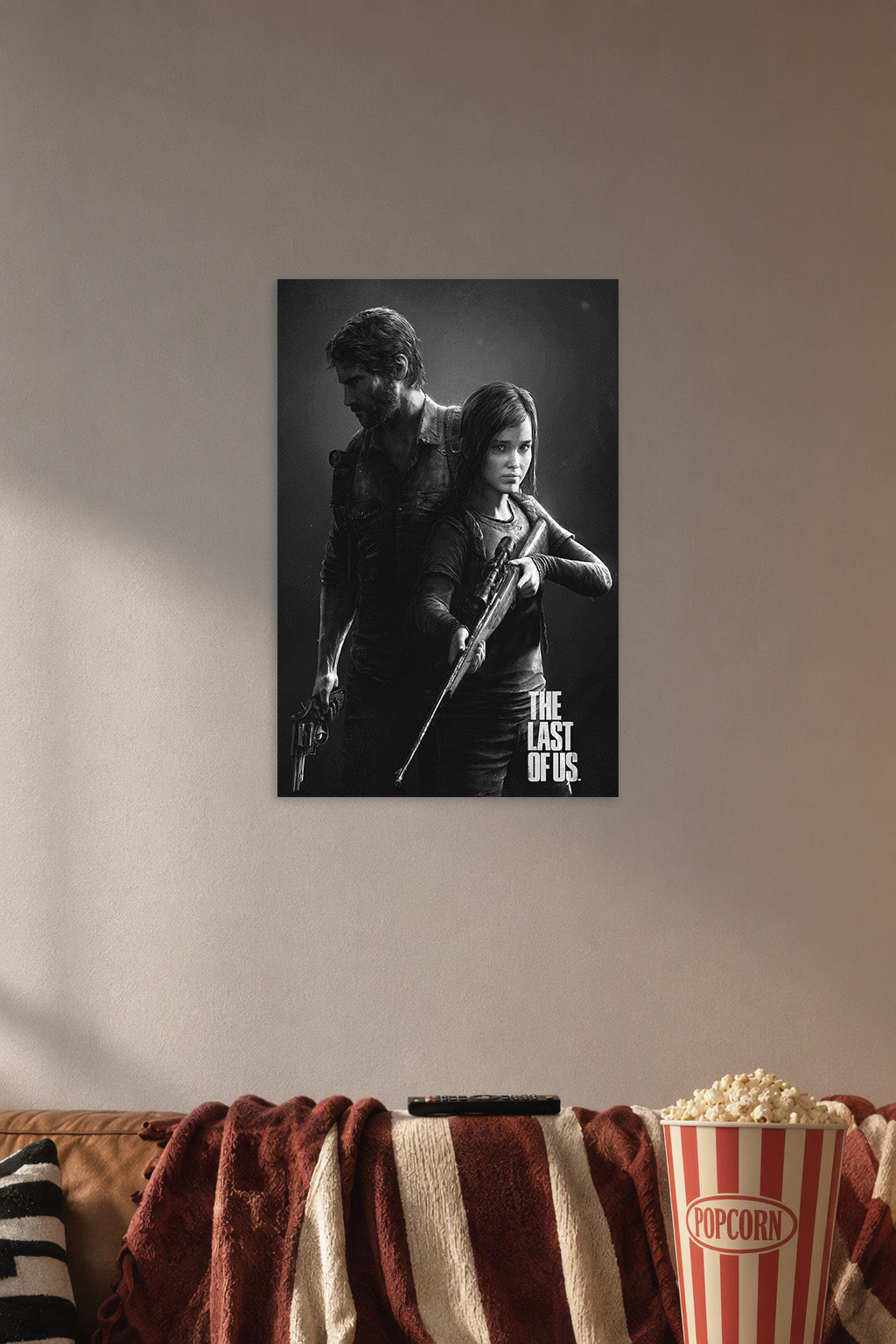 The Last of Us Joel and Ellie in a cozy movie room above a brown sofa with popcorn.