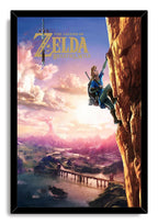 The Legend of Zelda Breath of the Wild framed wall art print portraying Link climbing a golden rock face above a lake and distant volcano.
