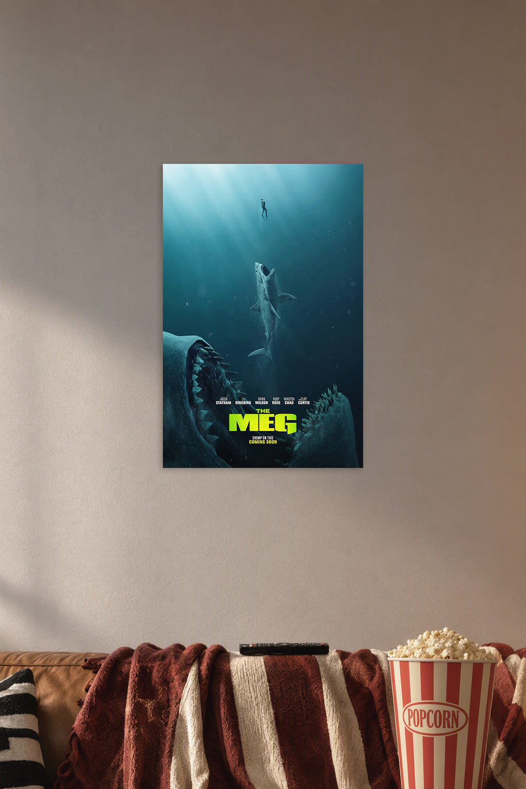 The Meg Movie Poster in a cozy movie room above a brown sofa with popcorn.