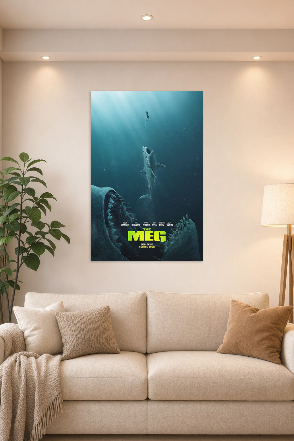 The Meg Movie Poster in a bright living room above a beige sofa.