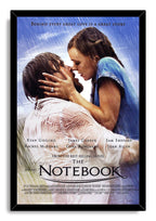 The Notebook framed wall art print presents a rain-soaked couple embracing in a black frame, with blue sky and movie typography.