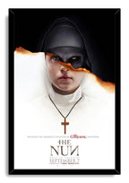 The Nun framed wall art print depicts a white-robed nun and wooden cross, with a fiery tear exposing Valak's shadowed face.