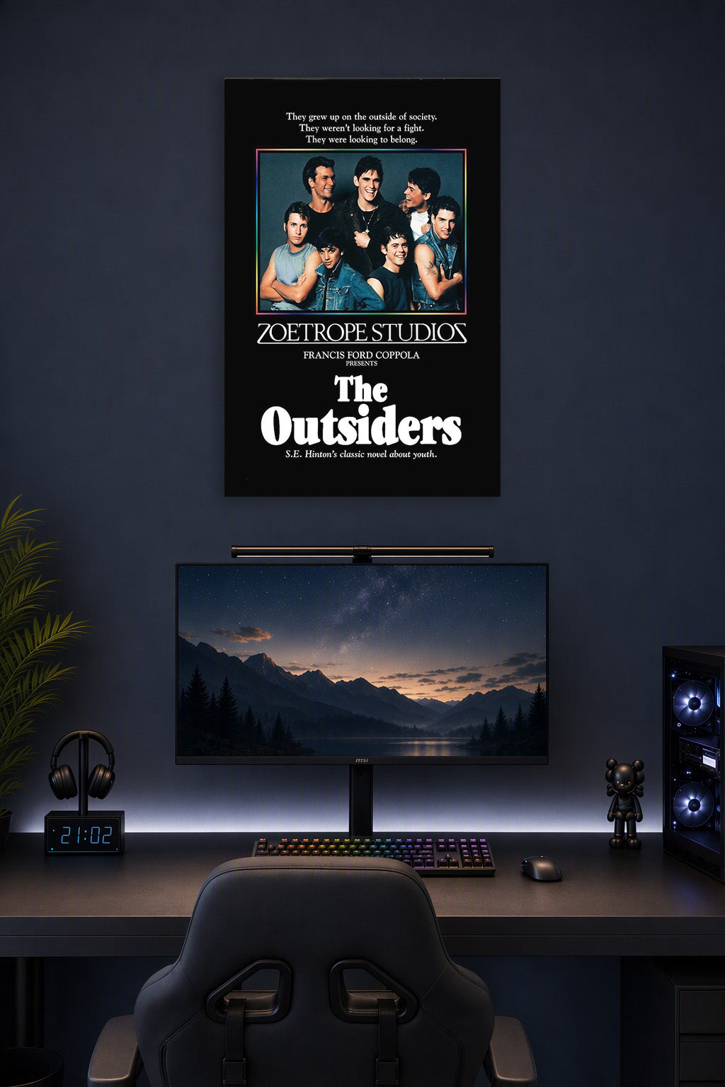 The Outsiders Movie Cast in a gaming desk setup above a monitor.