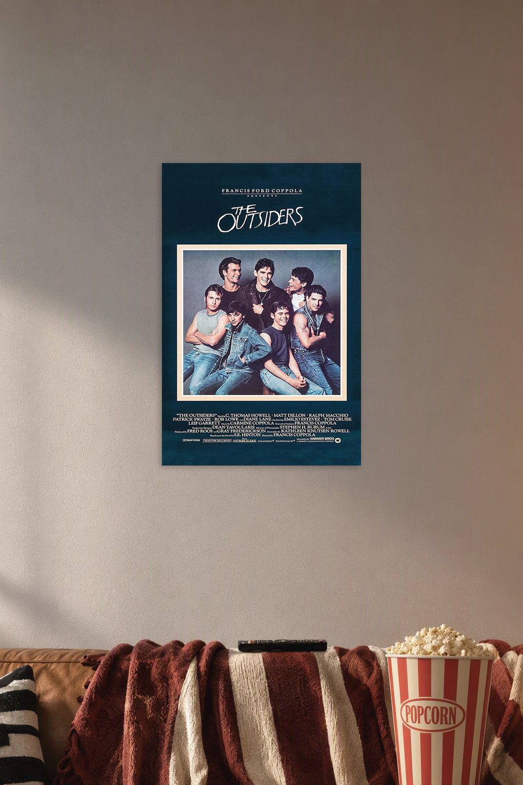 The Outsiders Movie Poster in a cozy movie room above a brown sofa with popcorn.