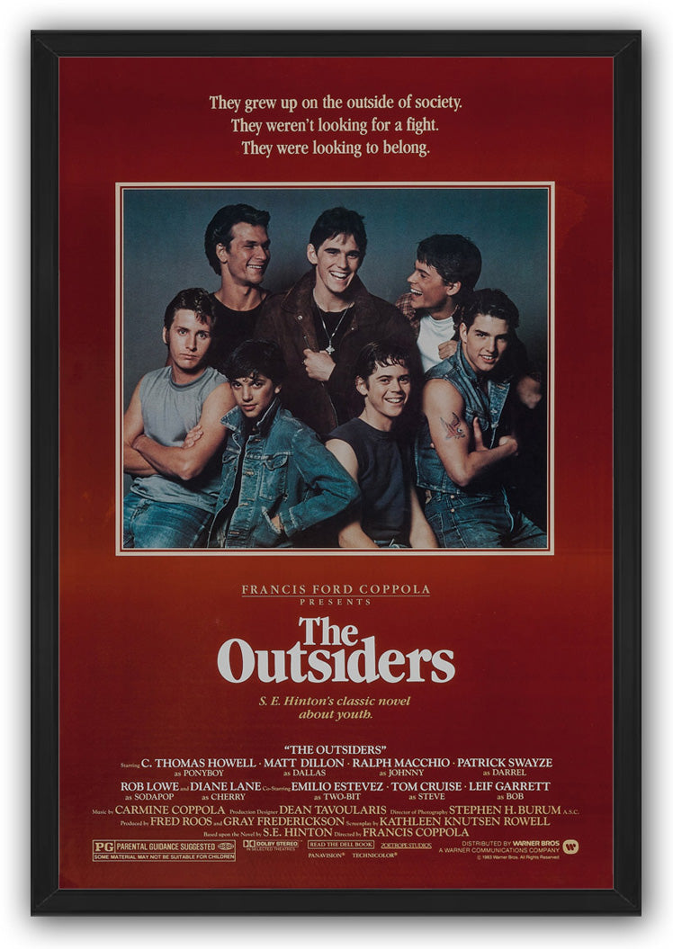 The Outsiders framed wall art print features seven young men in a central portrait with red surround, white text, and black frame.