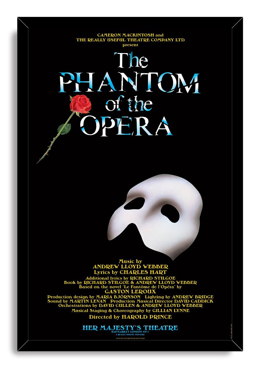 The Phantom of the Opera framed wall art print with a black frame, red rose, white mask, blue typography, and gold credits.