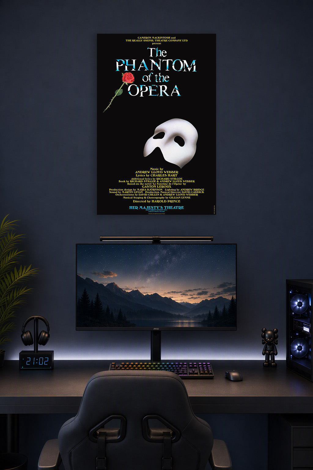 The Phantom of the Opera in a gaming desk setup above a monitor.