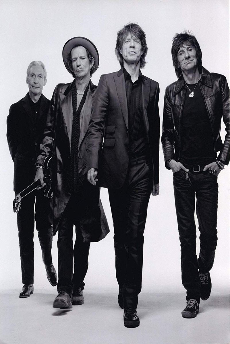 The Rolling Stones poster features four band members walking forward in black suits and leather jackets against a pale studio backdrop.