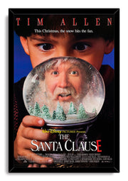 The Santa Clause framed wall art print features a close-up boy holding a snow globe with Tim Allen, snowy fir trees, and title text.
