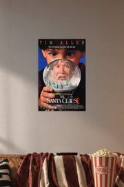 The Santa Clause Movie Poster in a cozy movie room above a brown sofa with popcorn.