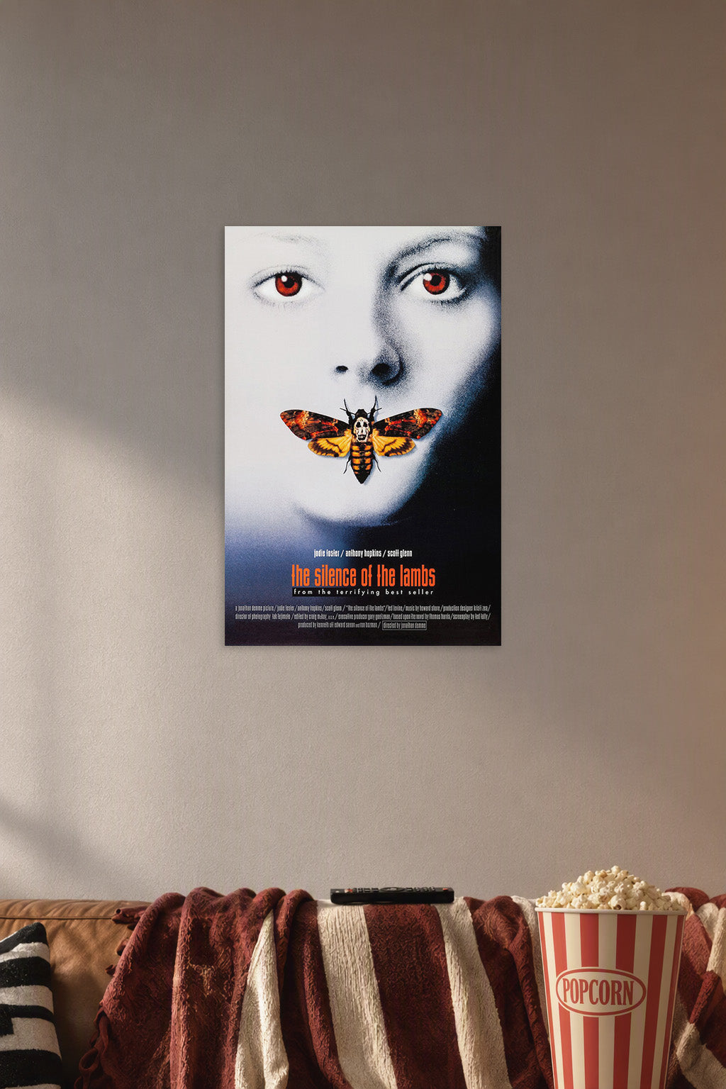 The Silence of the Lambs Movie Poster in a cozy movie room above a brown sofa with popcorn.
