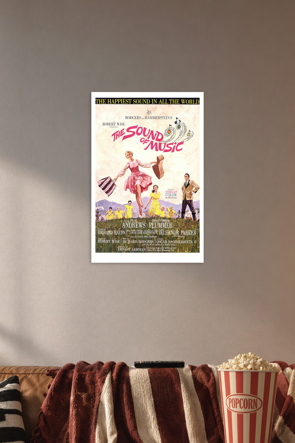 The Sound of Music in a cozy movie room above a brown sofa with popcorn.