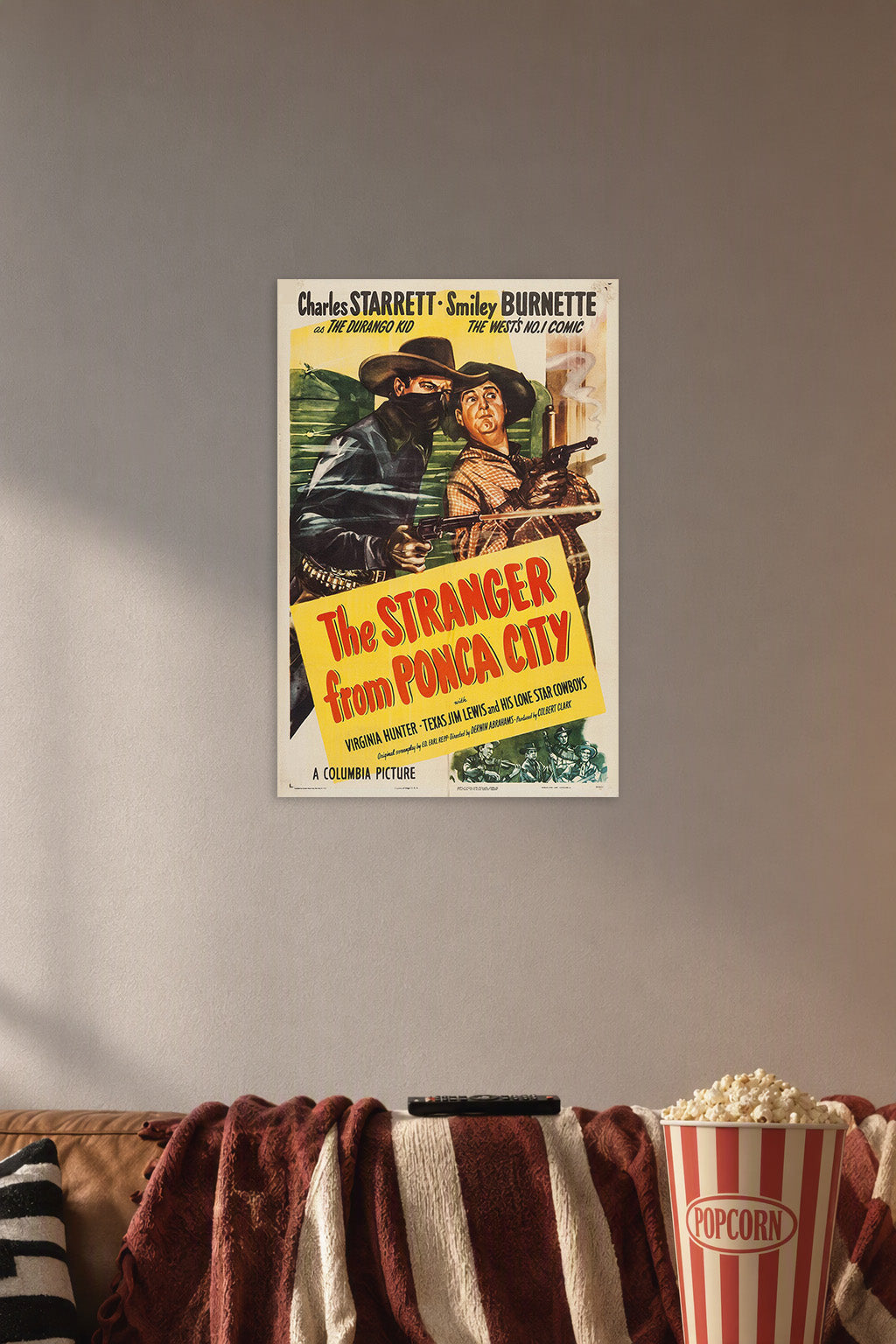 The Stranger from Ponca City Charles Starrett Smiley Burnette Western Movie in a cozy movie room above a brown sofa with popcorn.