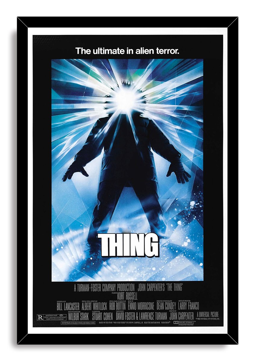 The Thing framed wall art print presents a dark figure beneath an explosive white glow, surrounded by blue crystalline rays.