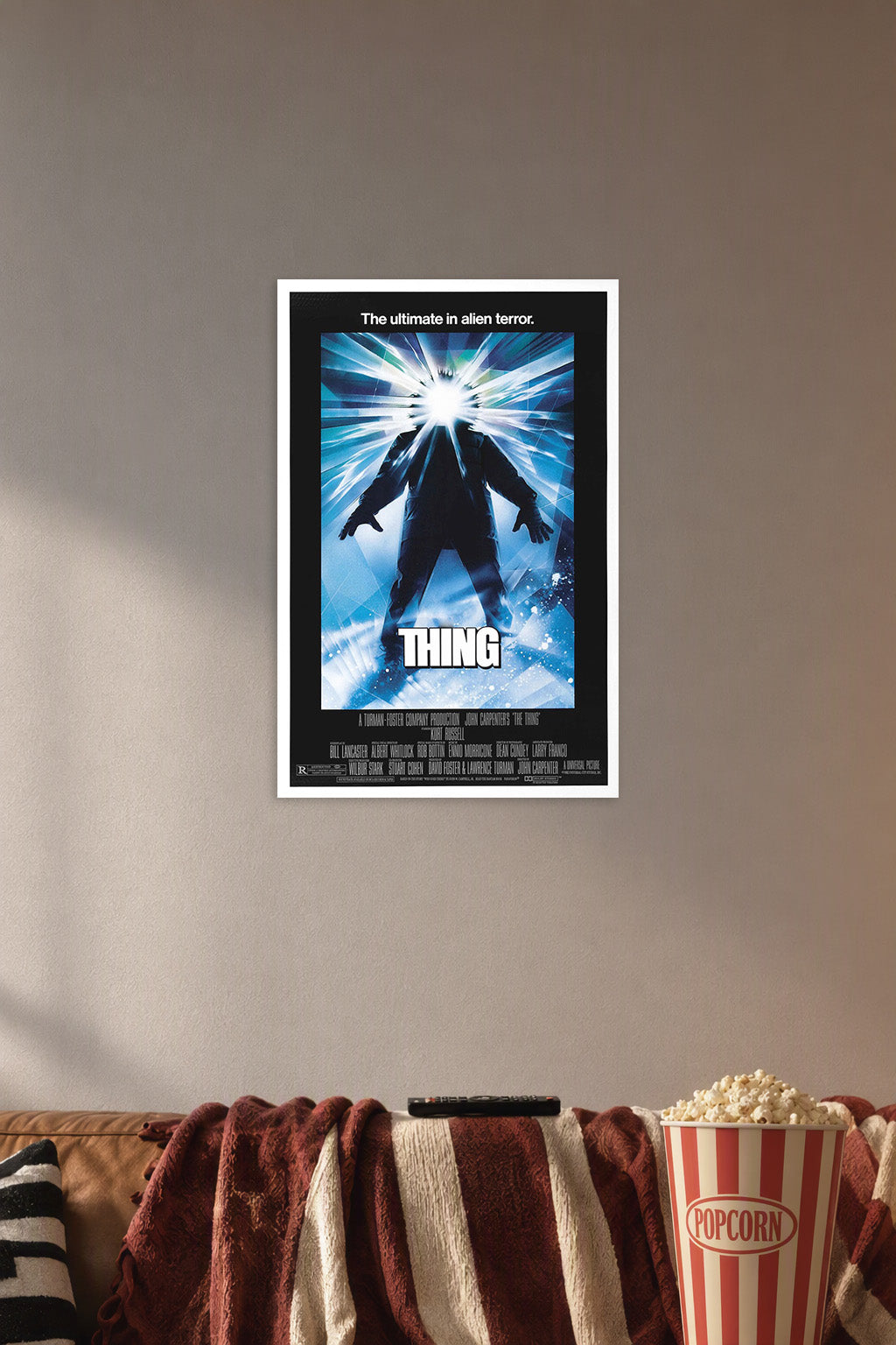 The Thing in a cozy movie room above a brown sofa with popcorn.