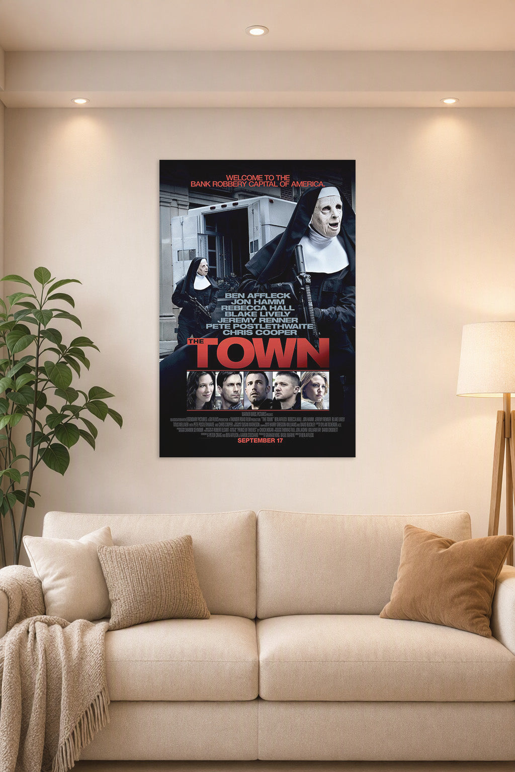 The Town Movie Poster in a bright living room above a beige sofa.
